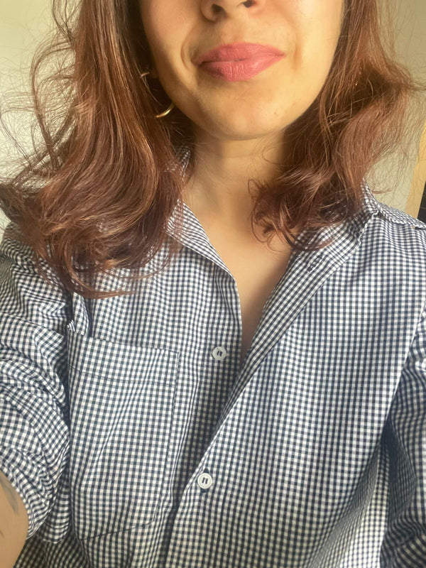 Person wearing a checkered shirt with a neutral background