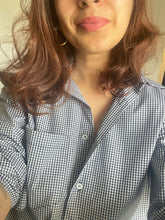 Person wearing a checkered shirt with a neutral background