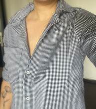 Person wearing a checkered shirt with a blurred background